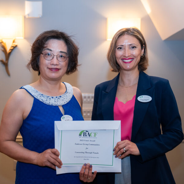 Two ELC staff members stand next to each other holding a certificate from the Barrington Area Community Foundation.
